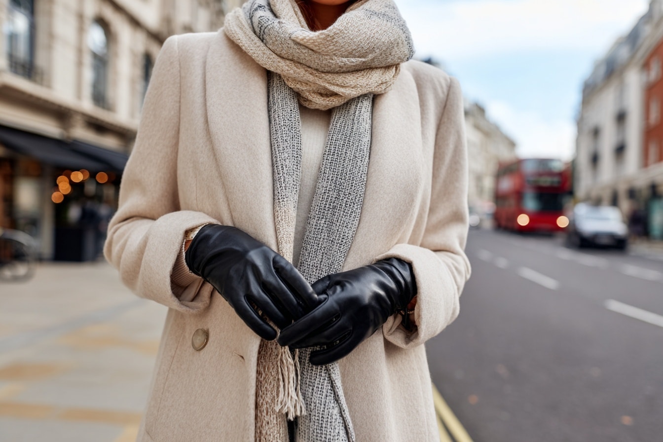 Frau mit beigem Mantel, grauem Schal und schwarzen Lederhandschuhen auf Londons Straße